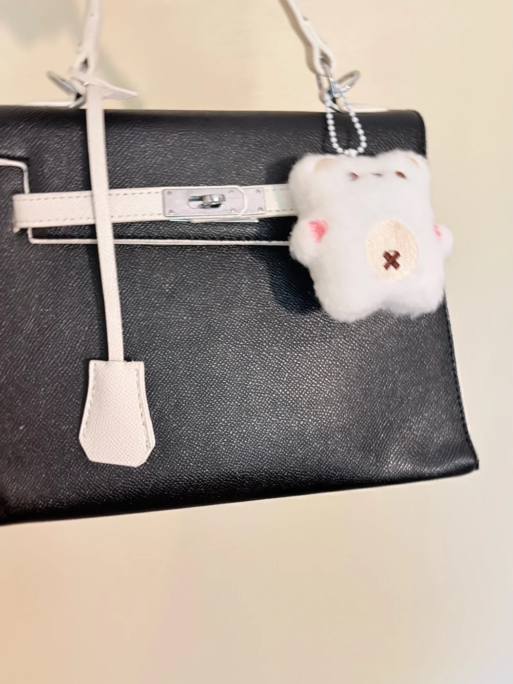 Black and White Structured Top-Handle Bag with Plush Charm